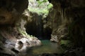 cave with waterfall cascading down the walls of the mountain, pooling in the bottom