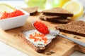 Caviar, bread, lemons and cutting board on light background