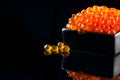 Caviar. Salmon caviar in a bowl over black. Closeup trout caviar