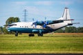 Cavok Air Antonov An-12 cargo plane at airport apron with marshaller. Air freight and shipping. Aviation and aircraft