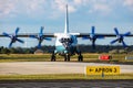 Cavok Air Antonov An-12 cargo plane at airport apron with marshaller. Air freight and shipping. Aviation and aircraft