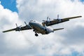 Cavok Air Antonov An-12 cargo plane at airport apron with marshaller. Air freight and shipping. Aviation and aircraft