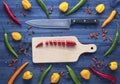 Cayenne chilli pepper on cutting board with various peppers all around Royalty Free Stock Photo