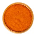 Cayenne pepper powder in wooden bowl over white