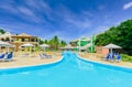 Pretty inviting view of Colonial hotel grounds, beautiful swimming pool and retro stylish buildings