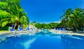 Amazing view of hotel grounds with nice inviting swimming pool and people in background in tropical garden