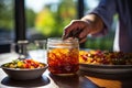 CBG Gummies. a person putting food into a jar on a table Royalty Free Stock Photo