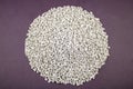 Raw material plastic granules white gray, close-up raw material brown background!