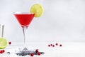 Cosmopolitan alcoholic cocktail drink with vodka, liqueur, cranberry juice, lime and ice. Gray table background, copy space