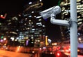 CCTV camera with blurring the night city in background. Royalty Free Stock Photo