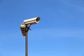 Outdoor surveillance cameras on a pole isolated on clear blue sky