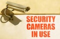 A CCTV camera is installed on the wall of the building, next to it is written - security cameras in use Royalty Free Stock Photo