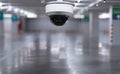 CCTV dome camera in empty parking garage with reflective floor and blurred background Royalty Free Stock Photo