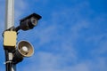 CCTV and loudspeaker alarm on a pole against a blue sky Royalty Free Stock Photo