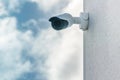 CCTV security camera in front blue sky background installed on white building wall Royalty Free Stock Photo