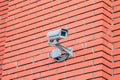 CCTV security camera on the red brick stone wall Royalty Free Stock Photo