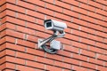 CCTV security camera on the red brick stone wall Royalty Free Stock Photo