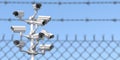 CCTV secutity cameras system and barbed wire fence. Privacy, security and protection concept