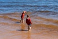 Ccute boys standing in water of Ladoga lake and looking into the distance. One boy is pointing somewhere. Royalty Free Stock Photo