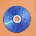 CD disk with water drops on shiny surface against orange background. Retro style and old technology  design Royalty Free Stock Photo