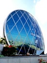 CD shape skyscraper with surroundings reflected on its facade