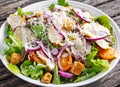 Ceasar salad with grilled chicken fillets, red onion rings, lettuce, orange cherry tomatoes, croutons, grated parmesan