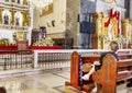 A devout Filipino worshiper,sits before the intricate golden altar of the Basilica of Saint Nino,Cebu\'s oldest church