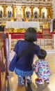 A Filipina woman and her small child,sit on the floor of the aisle at Saint Nino Church