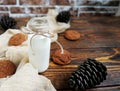 cedar milk in a small bottle with oatmeal cookies and cones on a wooden table and beige runner Royalty Free Stock Photo