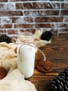 cedar milk in a small bottle with oatmeal cookies and cones on a wooden table and beige runner Royalty Free Stock Photo