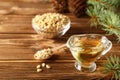 Cedar products: cedar oil, pine nuts, cones, brunches on a wooden broun background Royalty Free Stock Photo