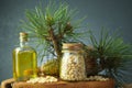 Cedar and spruce essential oil in glass bottle with pine nuts, cones composition