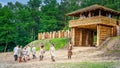 Historical reenactment of Slavic or Vikings warriors in front of wooden fort