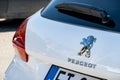 The logo of the Peugeot automotive company on a rear part of a modern white SUV 2008