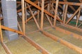 Ceiling and attic floor insulation made of rock wool between the trusses, visible system chimney.