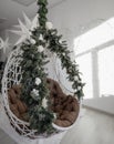 Ceiling hanging armchair decorated for the Christmas holidays New Year& x27;s decorations. New Year& x27;s interior.