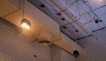 Ceiling lamp with opened light and air duct hanging on ceiling. Air conditioner pipe system. Air ventilation system. Fire sprinkle