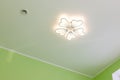 Ceiling with LED chandelier and air vent. Decorative LED chandelier in the form of a flower under the ceiling Royalty Free Stock Photo