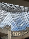 the ceiling in the museum has a glass pyramid and a skylight