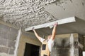 Plasterer smoothing plaster mortar on ceiling with screeder Royalty Free Stock Photo