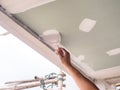 The ceiling worker is plastering the ceiling joints with high quality white gypsum plaster to keep the joints together