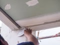 The ceiling worker is plastering the ceiling joints with high quality white gypsum plaster to keep the joints together