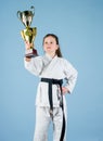 Celebrate achievement. Karate gives feeling of confidence. Strong and confident kid. Girl little child in white kimono Royalty Free Stock Photo