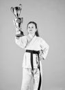 Celebrate achievement. Karate gives feeling of confidence. Strong and confident kid. Girl little child in white kimono Royalty Free Stock Photo