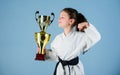 Celebrate achievement. Strong and confident kid. Girl little child in white kimono with belt. Karate fighter child Royalty Free Stock Photo