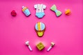 Celebrate birthday of a little baby. Cookies in shape of accesssories for child and gift box on pink background top view