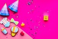 Celebrate child`s birthday. Cookies in shape of baby accesssories, party hats, gift box, confetti on pink background top