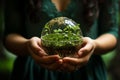 Celebrate earth day. Hands holding small green sprouts in lush spring grass
