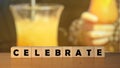 Celebrate message sign on a wooden desk on cube blockswith a drink resteurant