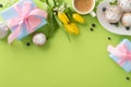Tendy table setting featuring cupcakes, presents, coffee cup, and tulips arranged in a top view flat lay on green background